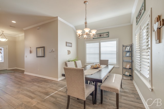 dining space featuring a chandelier, light hardwood / wood-style flooring, and crown molding