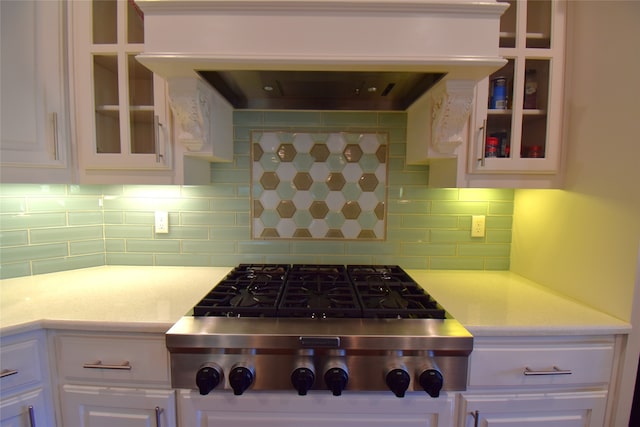 kitchen with white cabinets, ventilation hood, backsplash, and stainless steel gas cooktop