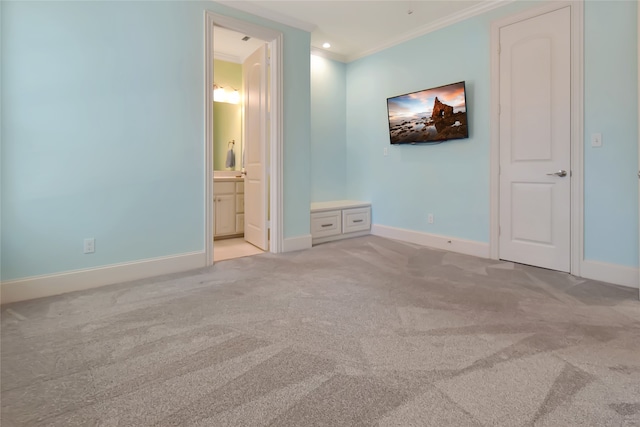 unfurnished bedroom featuring light colored carpet, ornamental molding, and connected bathroom