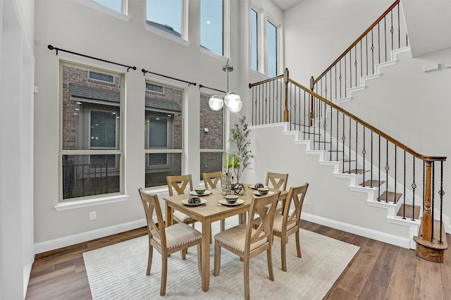 dining area with dark hardwood / wood-style flooring and a high ceiling