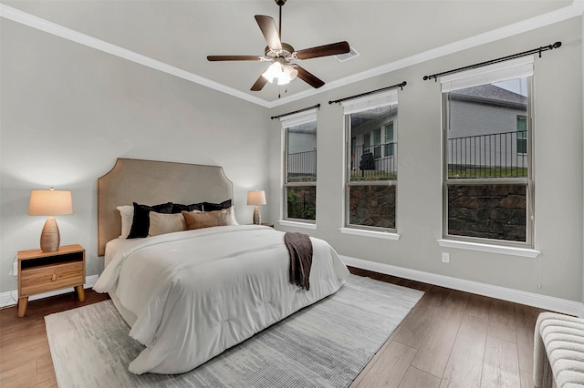 bedroom featuring ceiling fan, dark hardwood / wood-style flooring, and ornamental molding