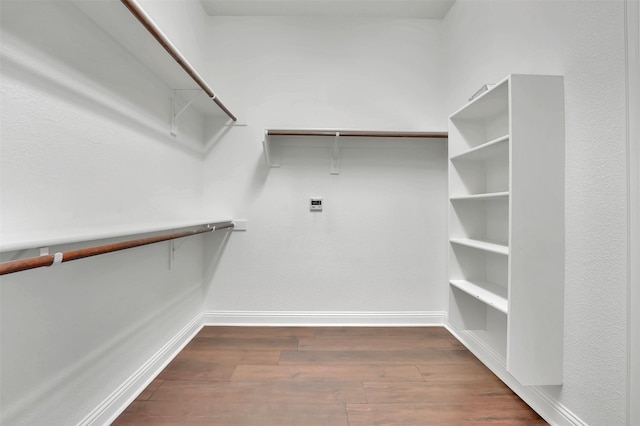 walk in closet with dark hardwood / wood-style floors