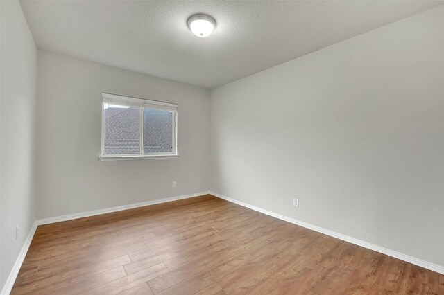 empty room featuring light hardwood / wood-style floors and a textured ceiling