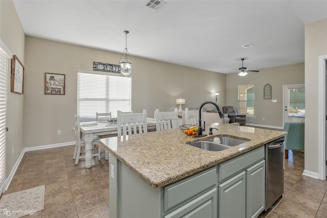 kitchen with pendant lighting, a center island with sink, a healthy amount of sunlight, and sink