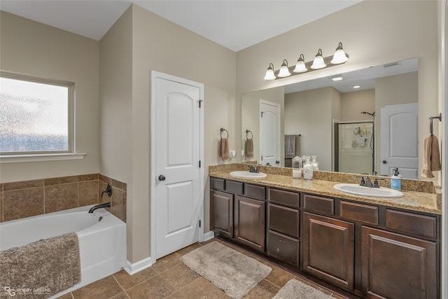 bathroom with tile patterned flooring, vanity, and shower with separate bathtub