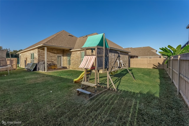 back of house with a playground, a trampoline, and a yard