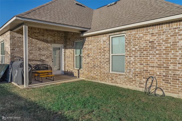 back of property with a yard and a patio area