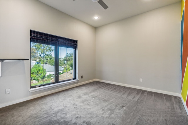 carpeted spare room featuring ceiling fan