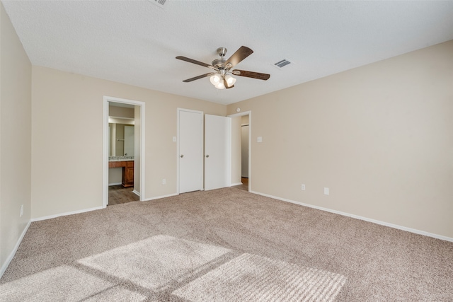 unfurnished bedroom featuring carpet, connected bathroom, and ceiling fan