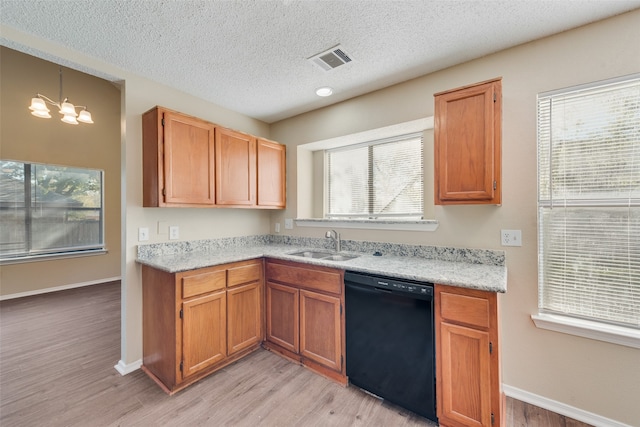 kitchen featuring a healthy amount of sunlight, light wood-type flooring, and black dishwasher