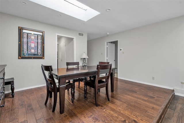 dining area with dark hardwood / wood-style floors and a skylight