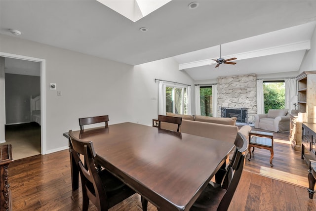 dining space with a wealth of natural light, vaulted ceiling with skylight, and dark hardwood / wood-style floors