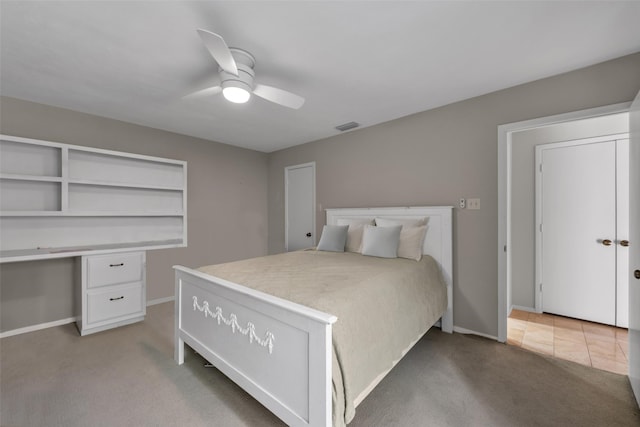 bedroom with ceiling fan, carpet floors, and built in desk