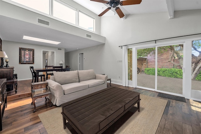 living room with ceiling fan, dark hardwood / wood-style flooring, and high vaulted ceiling