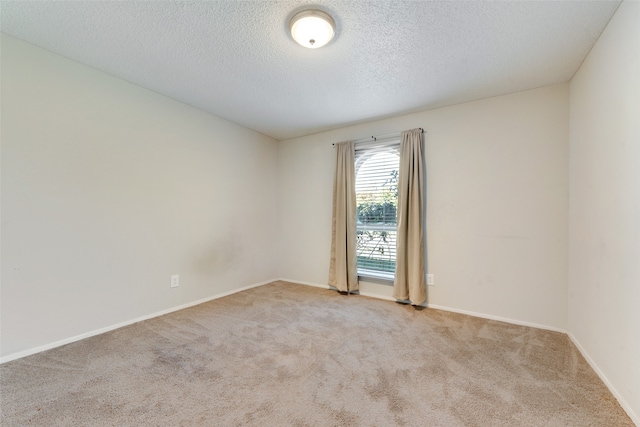 unfurnished room featuring a textured ceiling and light colored carpet