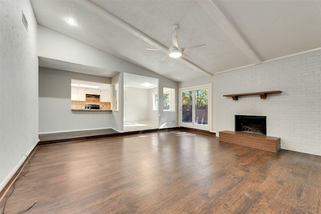 unfurnished living room with vaulted ceiling with beams, ceiling fan, wood-type flooring, and a fireplace