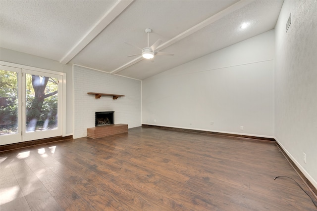 unfurnished living room featuring a brick fireplace, a textured ceiling, ceiling fan, vaulted ceiling with beams, and dark hardwood / wood-style floors