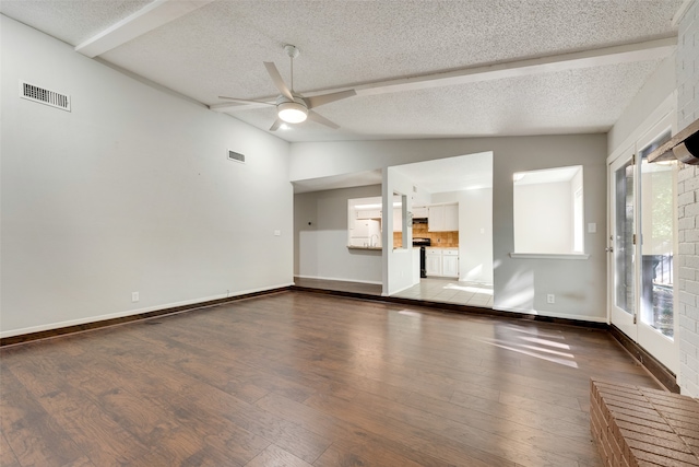 spare room featuring hardwood / wood-style floors, vaulted ceiling with beams, ceiling fan, and a textured ceiling