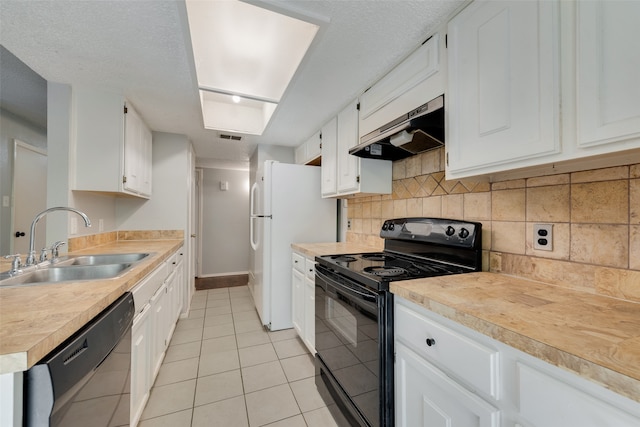 kitchen featuring sink, white cabinets, range hood, light tile patterned flooring, and black appliances