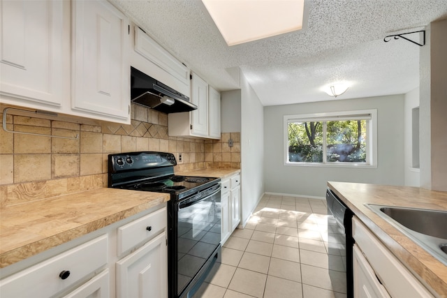 kitchen with backsplash, black appliances, range hood, light tile patterned flooring, and white cabinetry