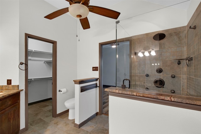 bathroom featuring vanity, toilet, a shower with door, and ceiling fan