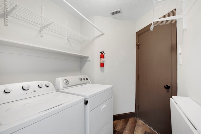 laundry area with separate washer and dryer, a textured ceiling, and dark hardwood / wood-style floors