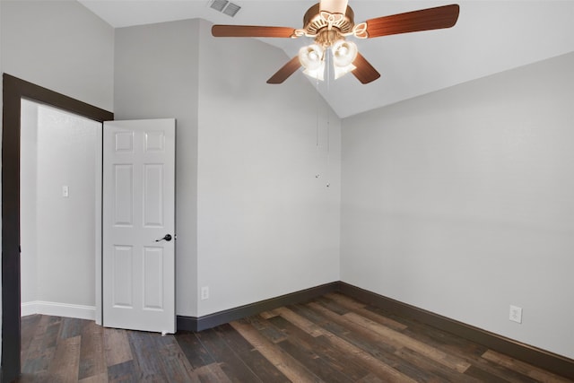 empty room with dark hardwood / wood-style flooring, vaulted ceiling, and ceiling fan