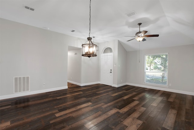 spare room with ceiling fan with notable chandelier, dark hardwood / wood-style flooring, and lofted ceiling