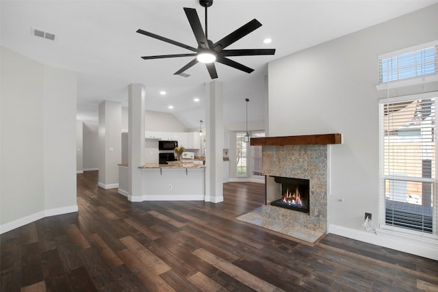 unfurnished living room with a premium fireplace, ceiling fan, dark wood-type flooring, and lofted ceiling