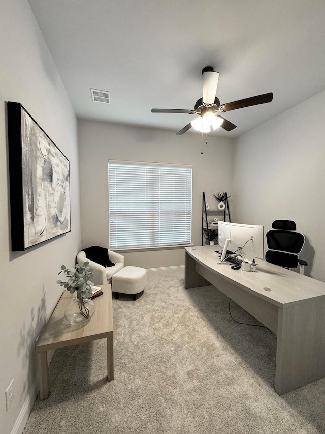 carpeted home office featuring ceiling fan