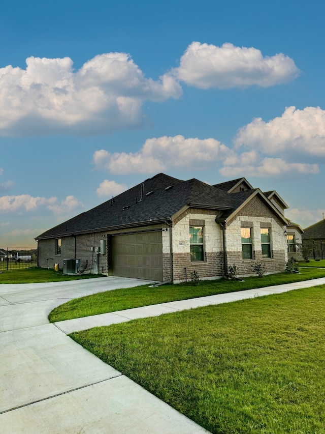 view of front facade featuring a garage, a front yard, and central air condition unit