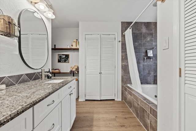 bathroom featuring hardwood / wood-style floors, vanity, and shower / bath combo with shower curtain