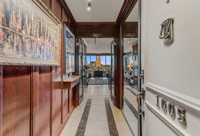 hall with light tile patterned floors and crown molding