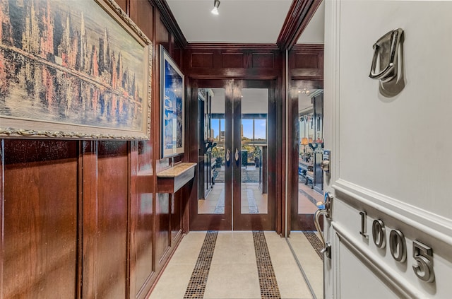 hall with ornamental molding and light tile patterned floors