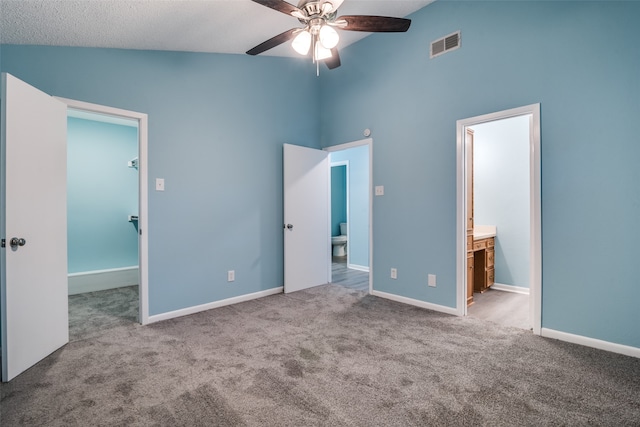 unfurnished bedroom with high vaulted ceiling, a walk in closet, ensuite bath, ceiling fan, and light colored carpet