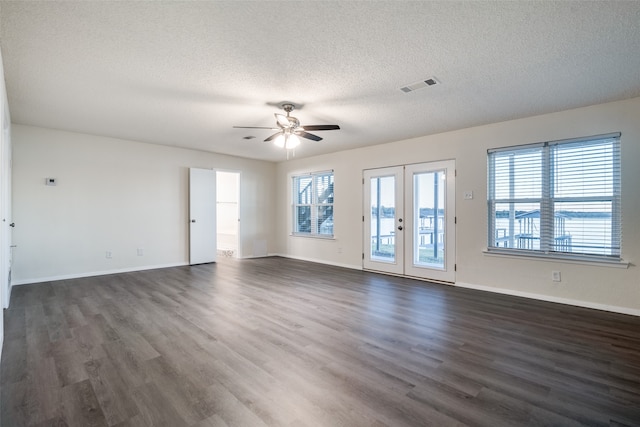 unfurnished room with ceiling fan, dark wood-type flooring, a wealth of natural light, and french doors