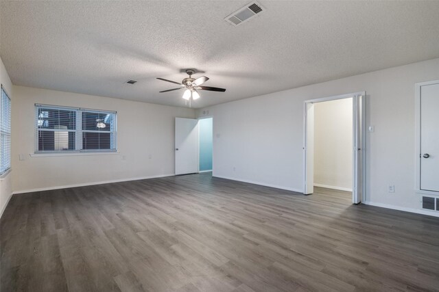 unfurnished room with a textured ceiling, ceiling fan, and dark wood-type flooring