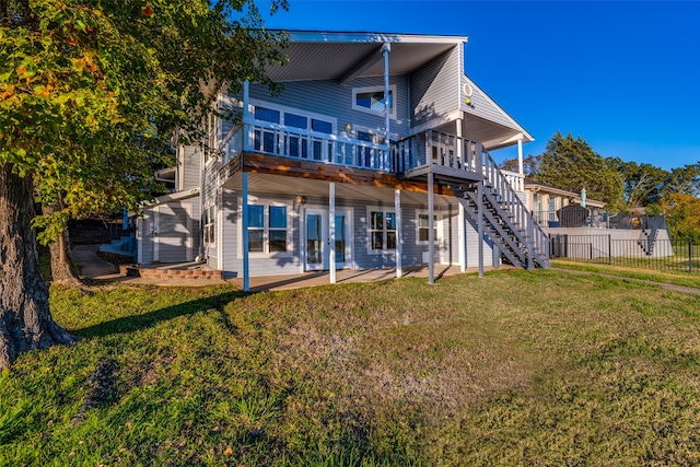 back of house featuring a yard, a deck, and a patio area