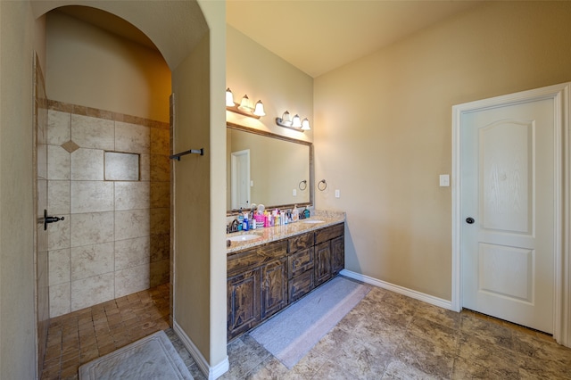 bathroom featuring vanity and tiled shower