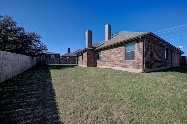 rear view of property featuring a lawn