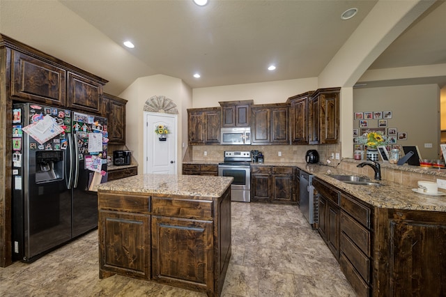 kitchen featuring kitchen peninsula, appliances with stainless steel finishes, dark brown cabinetry, and sink