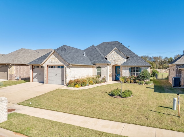 french country inspired facade with a front lawn, a garage, and central AC