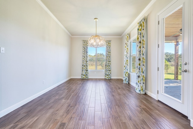 unfurnished dining area with a chandelier, dark wood-type flooring, a healthy amount of sunlight, and ornamental molding