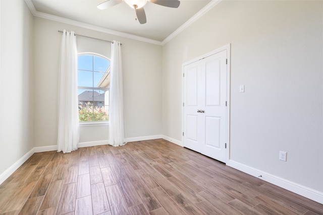 empty room featuring ceiling fan, ornamental molding, and light wood-type flooring