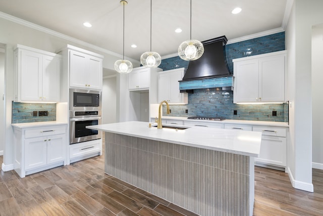 kitchen with oven, cooktop, built in microwave, custom range hood, and a sink