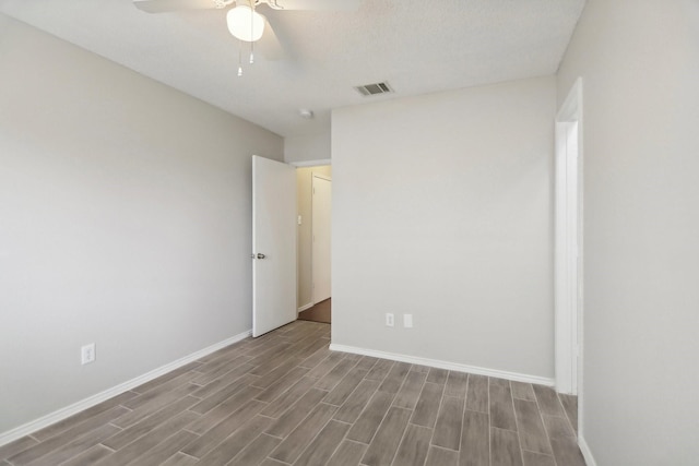 spare room featuring ceiling fan, a textured ceiling, and light wood-type flooring