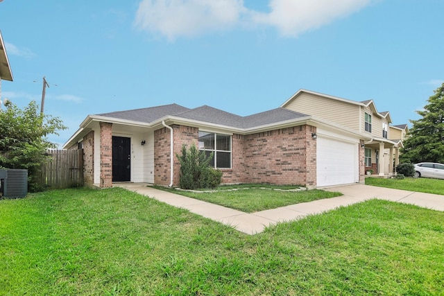 ranch-style house with a garage, central air condition unit, and a front lawn