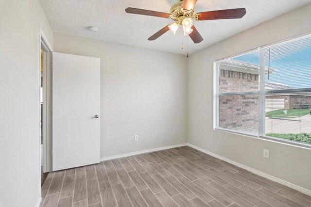 empty room featuring a textured ceiling, light hardwood / wood-style flooring, and ceiling fan