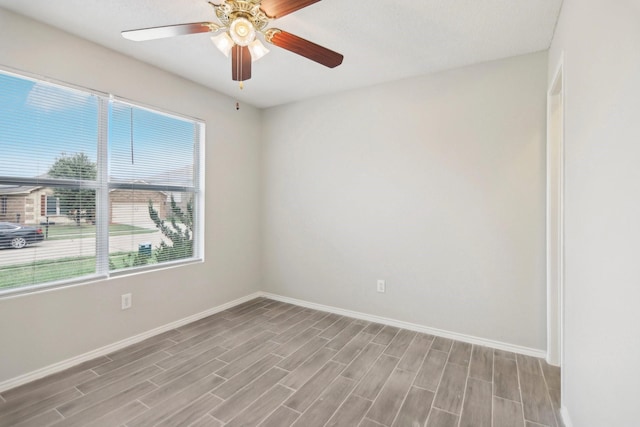 spare room featuring plenty of natural light, light hardwood / wood-style floors, and ceiling fan