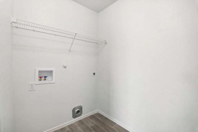 washroom featuring hardwood / wood-style flooring, washer hookup, hookup for a gas dryer, and hookup for an electric dryer